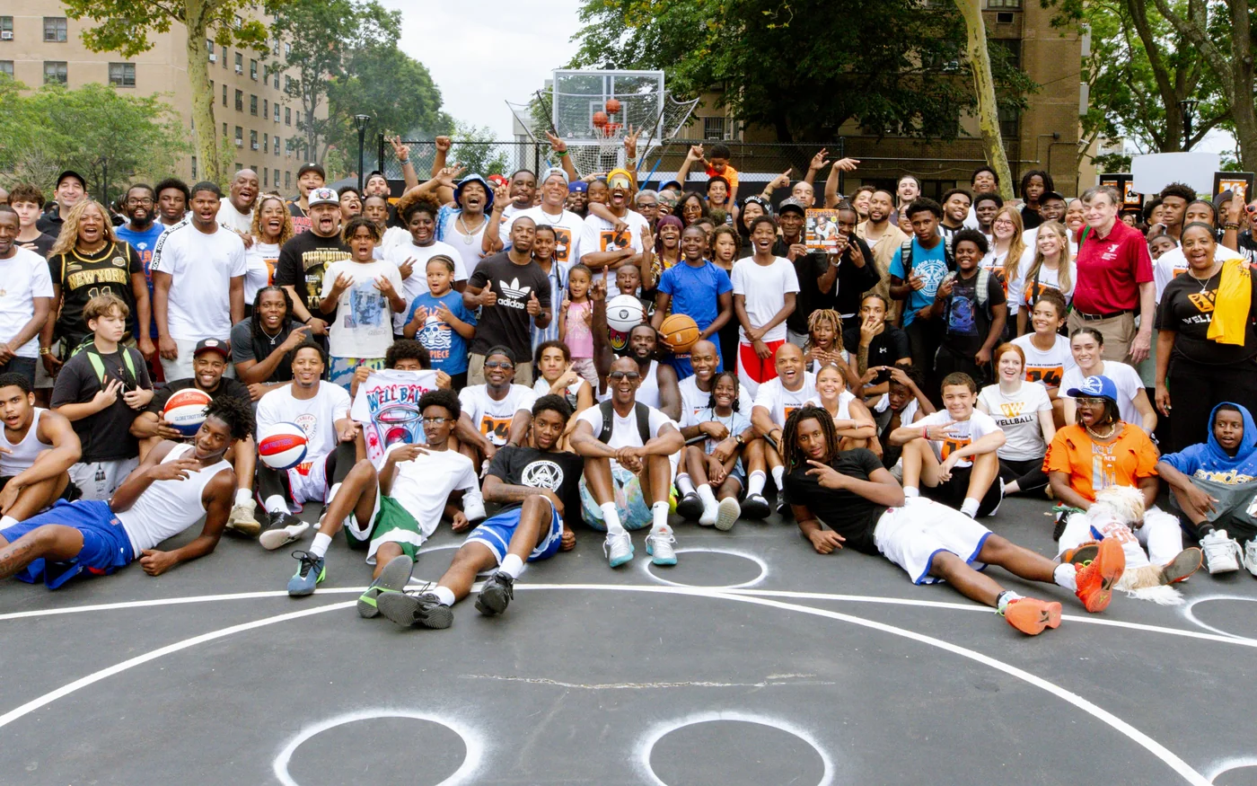 Athletes, families and community members gathered on an outdoor basketball court
